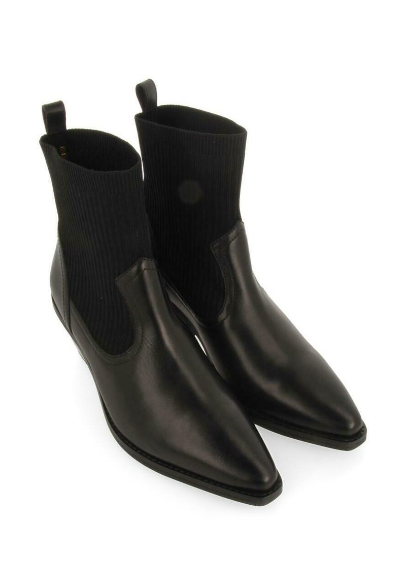 Botas de cuero negro hasta el tobillo con punta afilada, que cuentan con un eje de punto acanalado y tiradores para facilitar su uso. Textura suave y diseño minimalista.