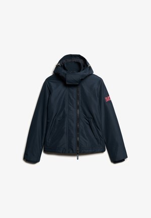 Mørkeblå vandtæt jakke med lynlås foran, justerbar hætte og to sidelommer. Har en struktureret overflade og et rødt logo på ærmet.