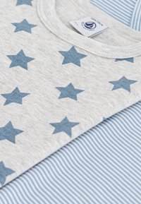 Gray fabric with blue star pattern and a round neck. Underneath, a light blue and white striped fabric is visible.