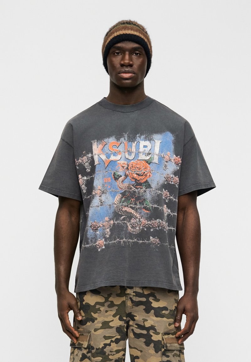 Γκρι υπερμεγέθες T-shirt με κοντά μανίκια, διακοσμημένο με πολύχρωμο γραφικό τύπωμα τριαντάφυλλων και φιδιού, συνδυασμένο με παντελόνι καμουφλάζ cargo.