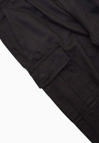 Pantalons cargo noirs dotés d'une poche latérale, fabriqués en tissu coton durable avec une texture lisse et des détails cousus.