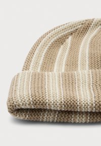 Beige gebreide beanie met opgevouwen manchet, met verticale crèmekleurige en witte strepen op een effen witte achtergrond.