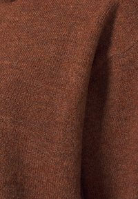 Brązowy włóczkowy sweter o fakturowanym wykończeniu, charakteryzujący się miękkim, dzianym wyglądem oraz subtelnym, melanżowym wzorem na całej powierzchni.