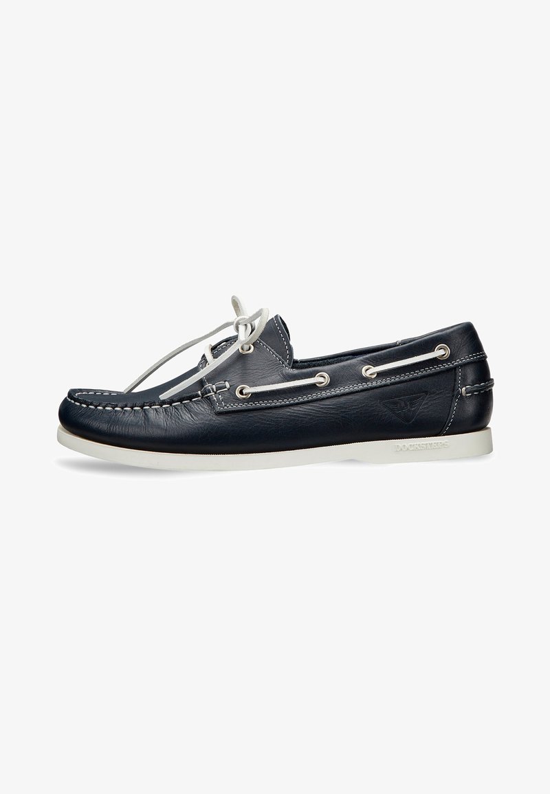 Scarpe da barca in pelle blu navy con punta arrotondata, lacci bianchi e cuciture a contrasto. Presentano una suola in gomma bianca e occhielli in metallo.