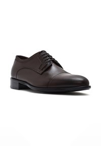 Bruine leren dresschoenen met een ronde neus, veterontwerp en een gladde afwerking. Kenmerkt zich door een lichte hak en subtiele stikselaccenten.