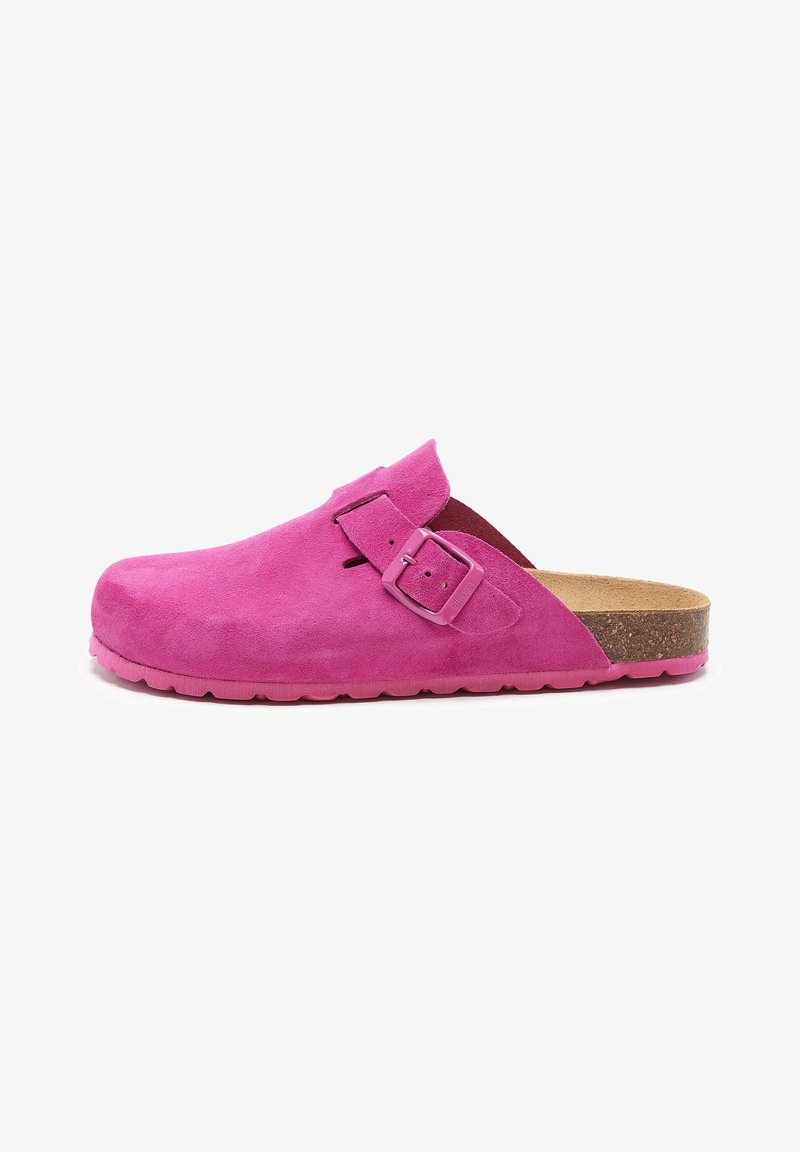 Sabot en daim rose vif à enfiler avec boucle réglable, semelle en liège et semelle extérieure texturée rose, vu de côté sur fond blanc.