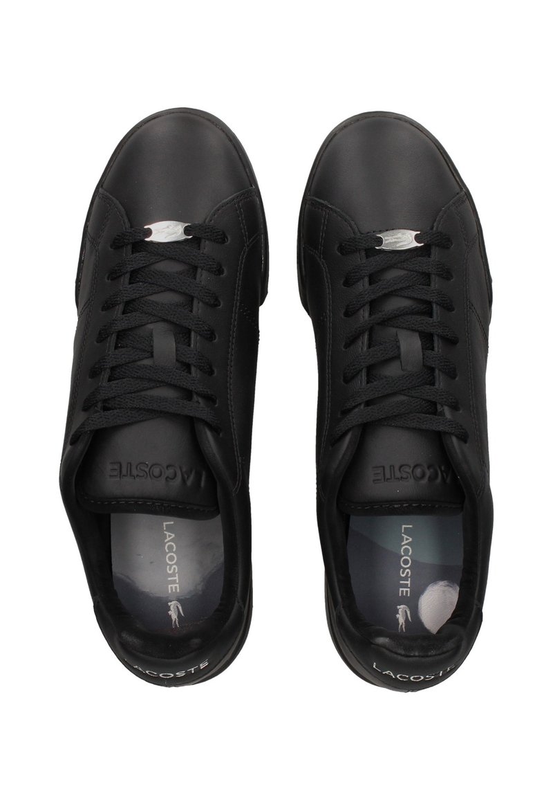 Baskets en cuir noir à finition lisse, lacets plats, bout arrondi et petit logo argenté sur le côté. Design simple avec un profil bas.