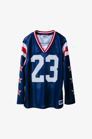 Tumesinise pikkade varrukatega jersei, mille kaeluse ja varrukate ääred on punased ja valged triibudega. Esiküljel on suur valge number "23" ja punased tähed varrukatel.