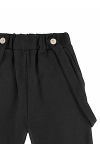 Czarne spodnie wykonane z materiału o gładkiej teksturze. Posiadają marszczony pas, dwie boczne kieszenie i drewniane akcenty w postaci guzików.