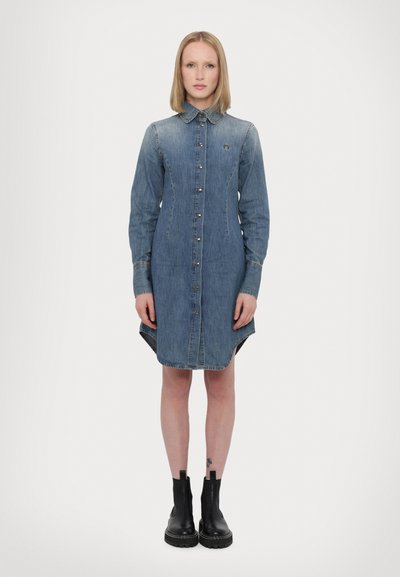 Rochie din denim, albastră deschisă, cu mâneci lungi, închidere cu nasturi în față, guler ascuțit, lungime până la genunchi cu tiv înalt și jos, având un mic logo pe piept.