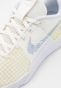 Lekki but sportowy z kremową i jasnoniebieską siateczką na cholewce, teksturowanymi akcentami oraz gumową podeszwą z falistym wzorem.