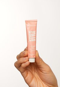 Pfirsichfarbene, matte Tube mit der Aufschrift "FREE STYLE" von The Body Shop, enthält 15 ml; hat einen weißen Deckel und fett gedruckten, weißen Text.