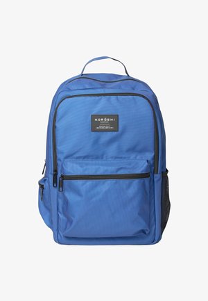Mochila rectangular azul con múltiples compartimentos con cremallera, bolsillo lateral de malla negra y un asa superior, etiquetada como "KOROSHI".