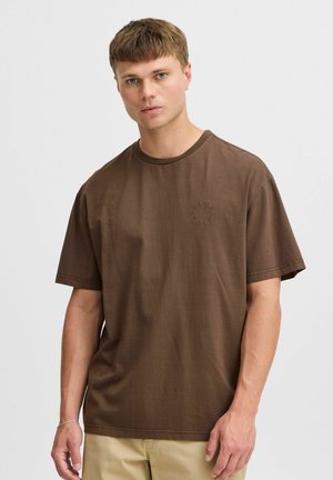 Brown cotton t-shirt with a relaxed fit, short sleeves, and a round neckline. Features a subtle embroidered logo on the front.