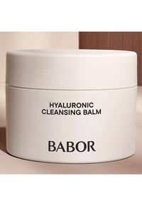 Vaso bianco tondo di balsamo detergente all'acido ialuronico con etichetta in testo nero. Finitura liscia; design minimalista; nessun accento o motivo aggiuntivo.