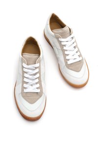 Weiße und hellgraue Sportschuhe aus Leder und Wildleder, mit einer gepolsterten Innensohle, weißen Schnürsenkeln und einer Gummisohle.