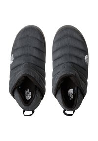Ett par svarta isolerade tofflor i slip-on-modell med The North Face-logotyp, quiltat mönster och dragflikar vid hälen mot vit bakgrund.