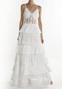 Hvid lagdelt kjole med intrikate blonderdetaljer ved bodice og kant, med en tætsiddende bodice og justerbare stropper.