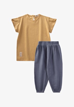 Mustard short-sleeve top with a back button closure, paired with gray elastic-waist pants, both in lightweight fabric. Features a small tag.