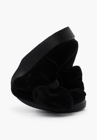 Sandalia de terciopelo negro con puntera redondeada y suaves detalles arrugados. Cuenta con una suela negra resistente y un tacón bajo, ligeramente curvado.