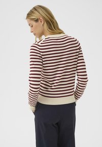Striped sweater in cream with maroon stripes, featuring ribbed cuffs and hem. View shows the back design and smooth knit texture.