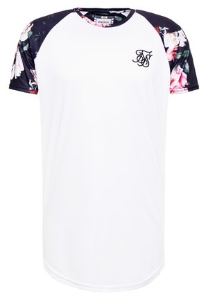 Hvid kortærmet skjorte med blomsterprintede sorte ærmer. Har rund halsudskæring og en lille logo på brystet. Glat stoftekstur.