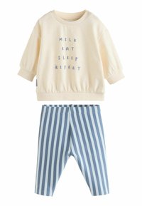 Crème sweatshirt met de tekst "MILK EAT SLEEP REPEAT," gecombineerd met blauwe en witte gestreepte zachte broek. Beide gemaakt van katoen.