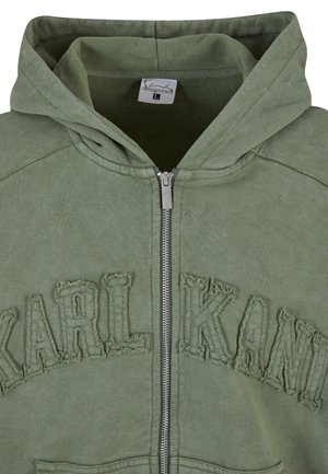 Zelená mikina na zips s textúrovaným logom "KARL KANI" na hrudi. Obsahuje kapucňu, predný zips a mäkký materiál.