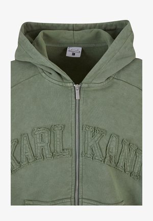 Roheline tõmblukuga kapuutsiga dressipluus, mille rinnal on tekstuuriga "KARL KANI" logo. Sisaldab kapuutsi, esimest tõmbluku ja pehmet kangast.