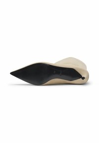 Beige suède stiletto hak met een spitse neus, een gladde textuur en een contrasterende zwarte zool. Opmerkelijk detail is een zijkant sluiting.