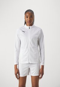 White athletic jacket with a high collar, featuring a black Puma logo on the chest, paired with matching white shorts. Smooth fabric texture.