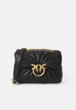 Juoda odinė rankinė su siuvinėta didele, turinti auksinės spalvos užsegimą, primenantį dvi paukščių figūras, ir grandinėlės dirželį.