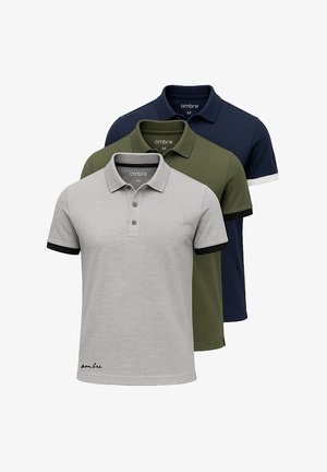 Trois polos en gris, vert olive et bleu marine ; à manches courtes, avec col, patte de boutonnage et finitions contrastées sur les manches.