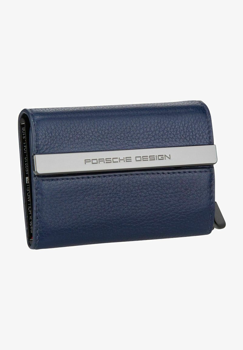 Portafoglio in pelle blu navy con una fascia metallica argentata su cui è inciso "PORSCHE DESIGN". Texture liscia con forma rettangolare.