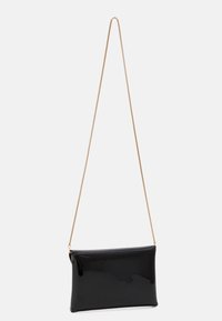 Musta patenttisaappaanruci oleva crossbody-laukku, jossa on suorakulmainen muoto, sileä pinta ja kultaketjuolkapäällys. Tyylikäs ja minimalistinen muotoilu.