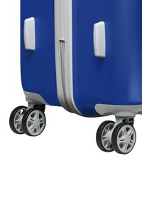 Blauwe harde koffer met een gestructureerd oppervlak, zilveren rits en vier multidirectionele zwarte wielen. Voorzien van witte handvatten aan de zijkanten.