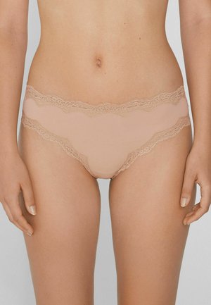 Helle beige Panties mit Spitze, einer glatten Oberfläche und einem gewellten Design am Bund, umrahmt von kunstvollen Spitzenverzierungen.