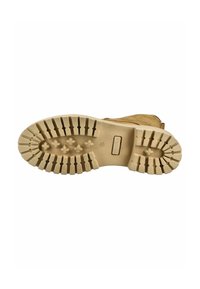 Treaded beige rubber sole with deep grooves and ridges for traction, featuring a smooth finish and an embossed logo near the heel.