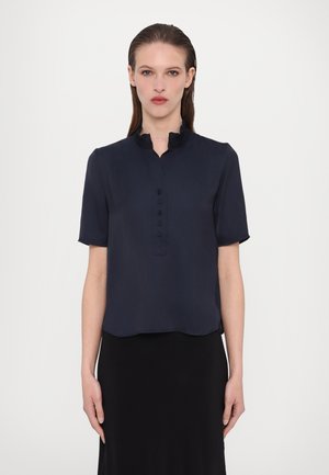 Tumesinine lühikeste varrukate blouse, millel on volangiga krae, nööpidega avamine ja ümar hem, valmistatud kergest, sileda kangast.