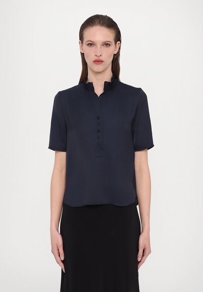 Navy blue short-sleeve blouse with a ruffled collar, buttoned placket, and a rounded hem, made from a lightweight, smooth fabric.