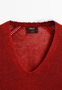 Maglione in lino rosso con scollo a V e design a maglia larga. Le etichette indicano "Massimo Dutti", "Made in China" e la composizione del tessuto.