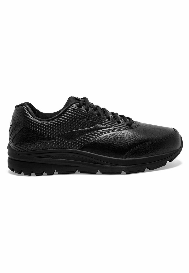 Schwarze Sportschuhe mit einem strukturierten Lederoberteil, Schnürdesign, gepolstertem Kragen und einer dicken Gummisohle für Halt.