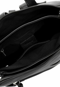 Sac à main en cuir noir avec un extérieur texturé, doté d'une fermeture éclair et d'un intérieur spacieux avec plusieurs compartiments et une doublure en tissu.
