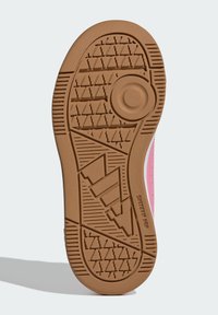 Podeszwa trampka wykonana z beżowego gumowego materiału z teksturowanym wzorem chwytającym i okrągłym detalem w centrum, podkreślającym geometryczny wzór.