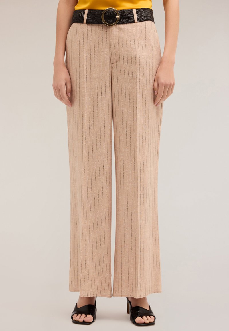 Beżowe spodnie o szerokich nogawkach z pionowymi paskami, z teksturowanym czarnym paskiem z dużą okrągłą klamrą. Gładka tkanina z luźnym krojem.