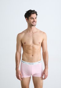 Calvin Klein herre boxershorts i blødt lyserødt stof, med en hvid elastisk talje med brandlogo. Tæt siddende design, korte ben.