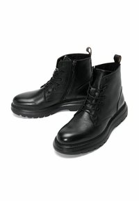Botas de tobillo de cuero negro con acabado texturizado, que cuentan con cierre de cordones y cremallera, suela de goma y tirador en el talón.