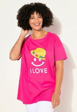 Roze katoenen T-shirt met een grafisch ontwerp van een lachend gezicht, voorzien van een gele stippenhoed. Loose fit en korte mouwen, met het woord "I LOVE" in het wit.