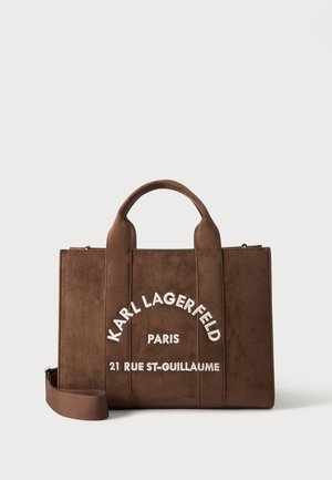 Brun ruskind tote taske med korte håndtag og aftagelig skulderrem, med hvid "Karl Lagerfeld Paris 21 Rue St-Guillaume" tekst foran.