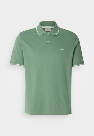Zielona koszulka polo wykonana z bawełny, z kołnierzykiem, dwuprzyciskową listwą oraz białym wykończeniem na rękawach, z delikatnym haftem logotypu.